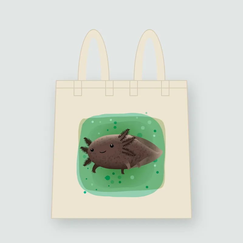 Tote bag de manta con la ilustración de un ajolote café sonriente sobre una mancha de agua verde.