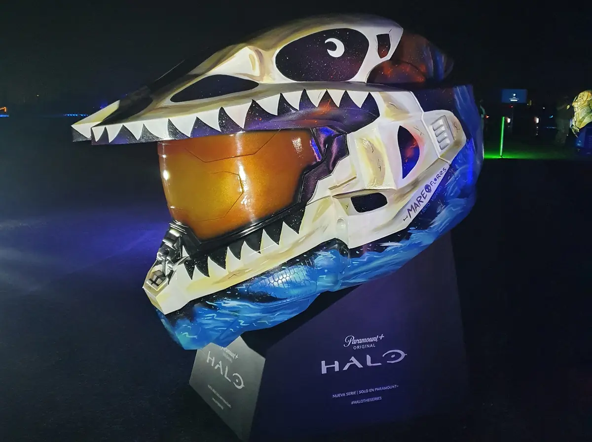 El casco visto de tres cuartos, de noche: un esqueleto de tiburón blanco recorre la parte de arriba y olas azules la base.
