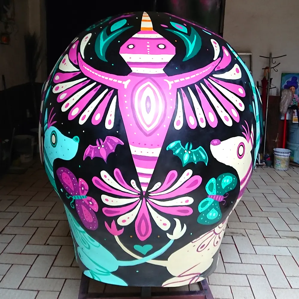 La parte trasera de la calavera, con un ave de alas rosas, murciélagos y ajolotes.